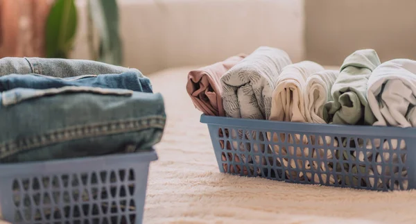 stock image Laid out clothes in blue containers on the bed.