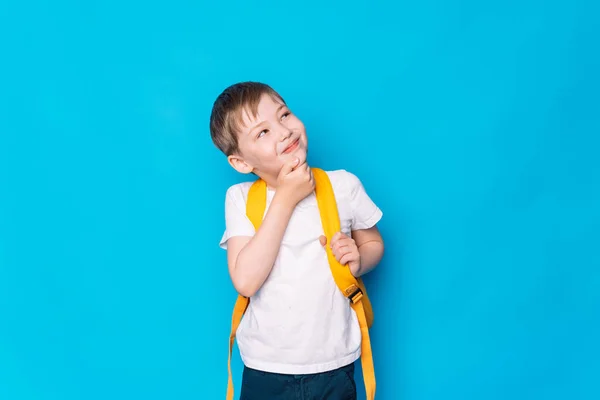 Αγόρι Ένα Κίτρινο Σακίδιο Σκέψης Μπροστά Από Ένα Μπλε Φόντο — Φωτογραφία Αρχείου