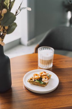 Karidesli tost ve beyaz tabakta marul ve kahve..