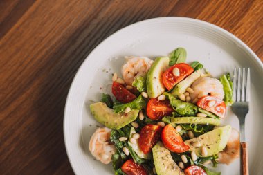 Beyaz tabakta fındıklı sebze salatası ve bir fincan kahve..