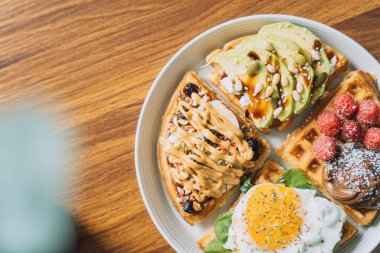 Beyaz tabakta farklı malzemelerle ev yapımı waffle 'lar..