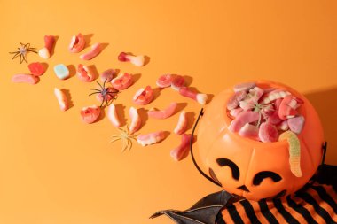 Turuncu arka planda marmelatla dolu balkabağı şekilli sepet..