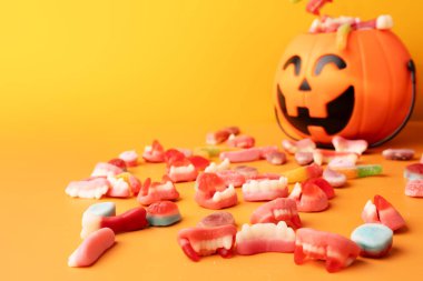 Turuncu arka planda şekerli balkabağı şeklinde sepet..