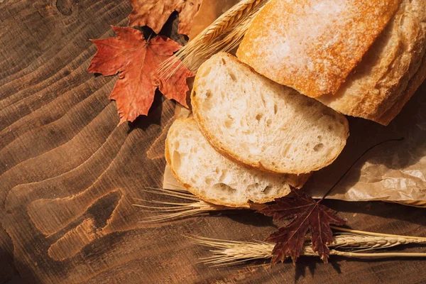 Świeży Bochenek Chleba Opakowaniu Papierowym Uszami Pszenicy Liśćmi Klonu Drewnianym — Zdjęcie stockowe