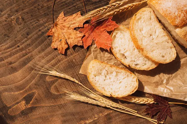 Świeży Bochenek Chleba Opakowaniu Papierowym Uszami Pszenicy Liśćmi Klonu Drewnianym — Zdjęcie stockowe