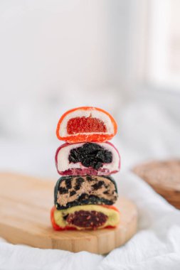 Böğürtlen jölesi ve ahşap bir tahtada çikolata dolu renkli yarım mochi..