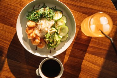 Avokado ve karides hafif atıştırmalıklar, yuvarlak tabakta soğuk içecek, ahşap masa..