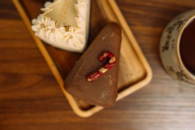 Noel ağacı şeklindeki çikolatalarla süslenmiş Noel pastaları ahşap tepside.