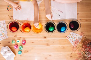 Çocuklar Paskalya için cam tabaklara yumurta boyarlar..