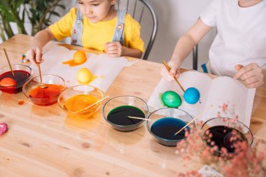 Çocuklar Paskalya için yumurtaları cam tabaklara boyarlar..