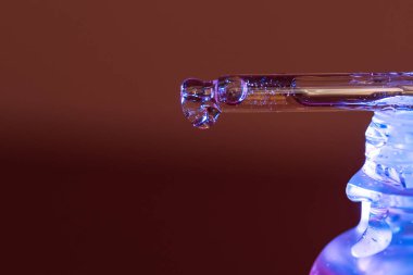 Bir damla serum pipetten mavi bir kavanoza akar. Yüksek kalite fotoğraf