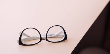 Açık bir yüzeyde siyah çerçeveli katlanmış görüş gözlükleri..