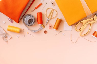 Hafif bir arkaplanda çeşitli çalışma araçları ve dikiş malzemeleri.