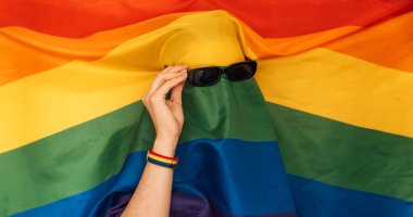 LGBT bayrağı güneş gözlüğü takan bir adamın üzerinde.