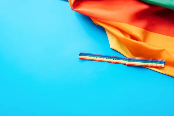 stock image LGBT flag and wrist strap on blue background.