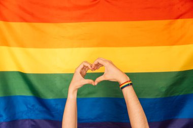 Eller LGBT bayrağına karşı sevgi ve kalp gösteriyor.
