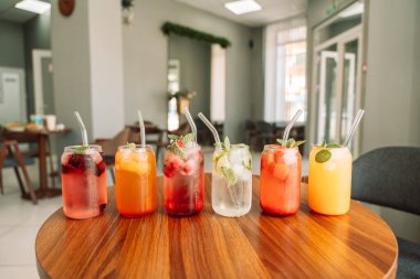 Böğürtlenli meyve içecekleri ve tahta bir masada cam bardakta buz..