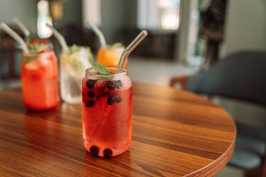 Cam bardaklar ve pipetlerle buzlu dut içecekler..