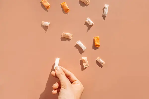 Bir kadının eli kahverengi arka planda farklı bir kese serer..