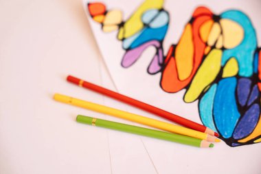 Beyaz kağıt üzerinde renkli kalemlerle renklendirilmiş nörografik çizim.