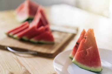 Tahta kesme tahtasındaki üçgen karpuz parçaları..