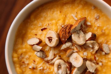 Beyaz kasede fındıklı mısır lapası, dikey fotoğraf..