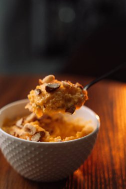 Beyaz kasede fındıklı mısır lapası, dikey fotoğraf..