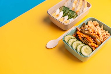 Parlak sarı ve mavi arka planda ev yapımı sağlıklı yiyecekler olan iki plastik beslenme çantası. Yüksek kalite fotoğraf