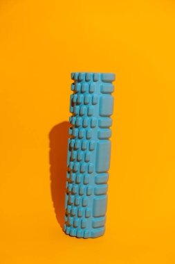 Turuncu stüdyo arka planında duran desenli mavi köpük silindirli fotokopi alanı ile aktif kurtarma ekipmanı. Yüksek kalite fotoğraf