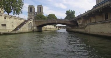 Bateau-mouche sailing on the Seine and passing under the Petit Pont near Notre Dame of Paris.