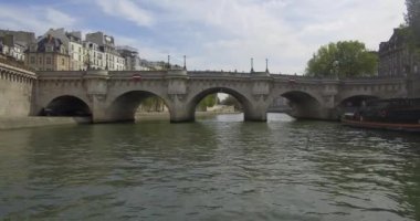 Bateau-mouche sailing on the Seine and passing under the Pont Neuf in Paris.