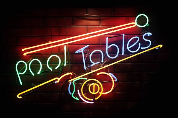 Close-up on a neon light shaped into cue and balls with the phrase \