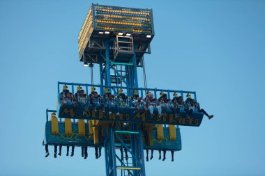 Saint Denis, Reunion - May 14 2016: Group of teenagers enjoying a ride on a drop tower during the fun fair.