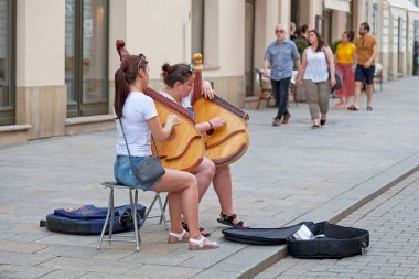 Krakow, Polonya - Haziran 06: 2019: Turistik bir sokakta banduras oynayan iki genç kadın. Bandura bir Ukraynalı, koparılmış ip, halk enstrümanı..