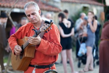 Bazoges-en-Pareds, Fransa - 29 Temmuz 2017: Yıllık 'Nocturnes Ortaçağ' festivali sırasında gitar çalan bir ortaçağ ozanı.