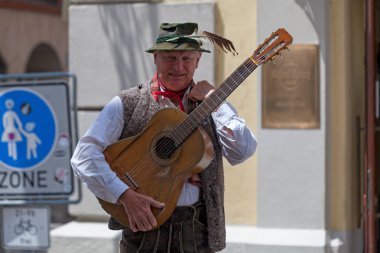 Münih, Almanya - 30 Mayıs 2019: Geleneksel giysili müzisyen gitarını şehir merkezinde tutuyor.
