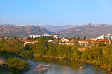 Podgorica, Karadağ - 20 Nisan 2019: Dinarik Alplerin bazı zirvelerinin ardında Moraca Nehri.