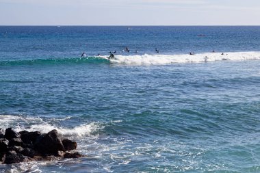 Saint Gilles Bains, La Reunion - 13 Haziran 2017: Plage des Roches Noires 'te sörf yapan gençler).