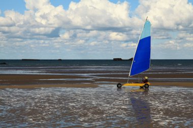 Arromanches, France - October 14 2012: Land sailing on Gold Beach in Normandy. In the background, we can still see the remnants of the WW2.