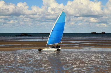 Arromanches, France - October 14 2012: Land sailing on Gold Beach in Normandy. In the background, we can still see the remnants of the WW2.