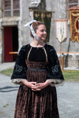 Plonevez-Porzay, France - August 29 2021: Young woman in traditional Breton dress during the Pardon of the Sainte-Anne-la-Palud Chapel.