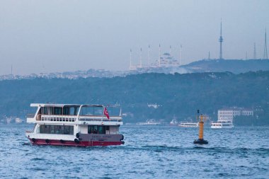 Istanbul, Turkey - May 11 2019: Ferry on the Bosphorus passing in front of the Camlica Mosque. It is the largest mosque in Turkey with a capacity of 63,000 people.