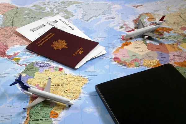 法国巴黎 2016年9月25日 世界地图 上有两架玩具飞机 一个封闭的黑色记事本和一张装有两张机票的法国护照 — 图库照片