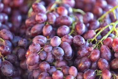 Close-up on a stack of Red Grapes for sale on a market stall.