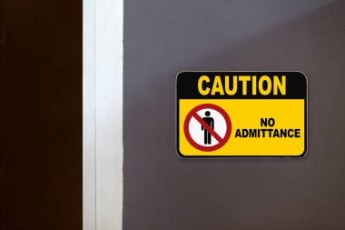 Black and yellow caution sign on the side of an open door stating 