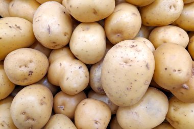 Close-up on a stack of potatoes for sale on a market stall.