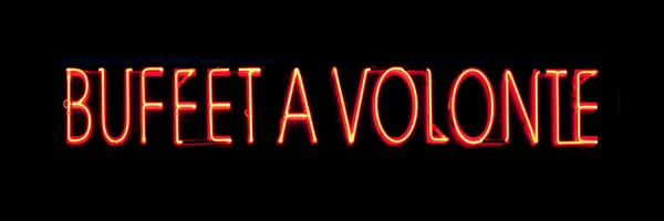 Red neon light shaped into the French phrase Buffet a Volonte which can be translated as Buffet All you can eat.