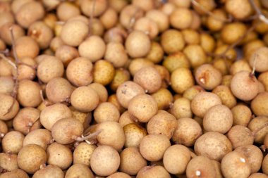 Close-up on a stack of Longan for sale on a market stall.