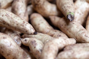 Close-up on a stack of Sweet Potatoes for sale on a market stall.