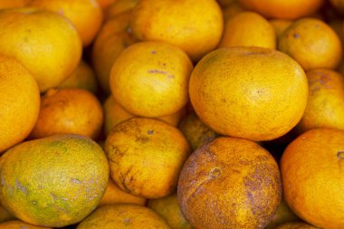 Full frame close-up on a stack of Oranges from Reunion Island on a market stall.